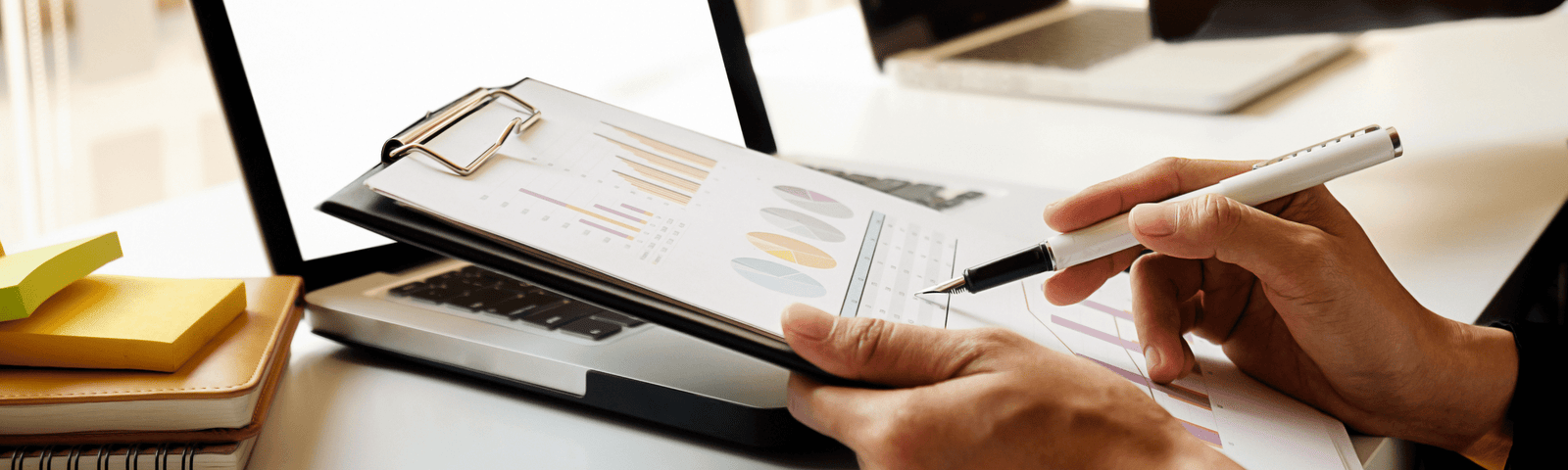 Duas pessoas trabalhando em uma mesa com seus notebooks e analisando sua consultoria Data Analytics e Data Science.